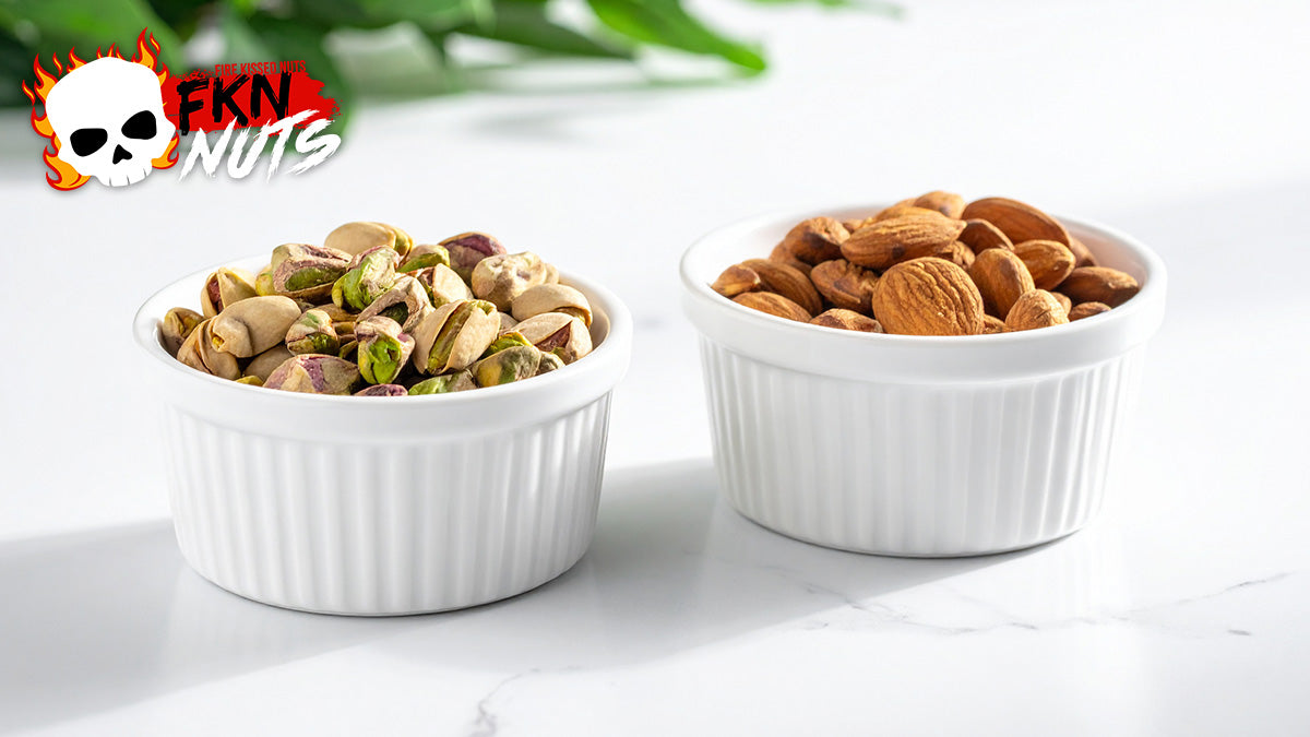 Side-by-side white ceramic bowls of shelled pistachios and whole almonds on white marble, clean overhead product photography